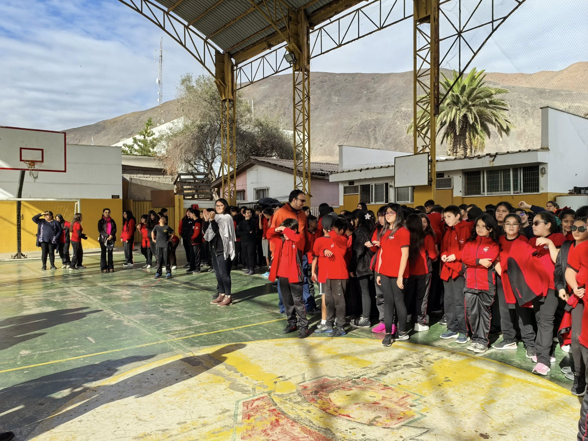 Estudiantes de la Escuela Victor Hugo Carvajal Meza durante un acto matinal con su tradicional buzo rojo y negro.