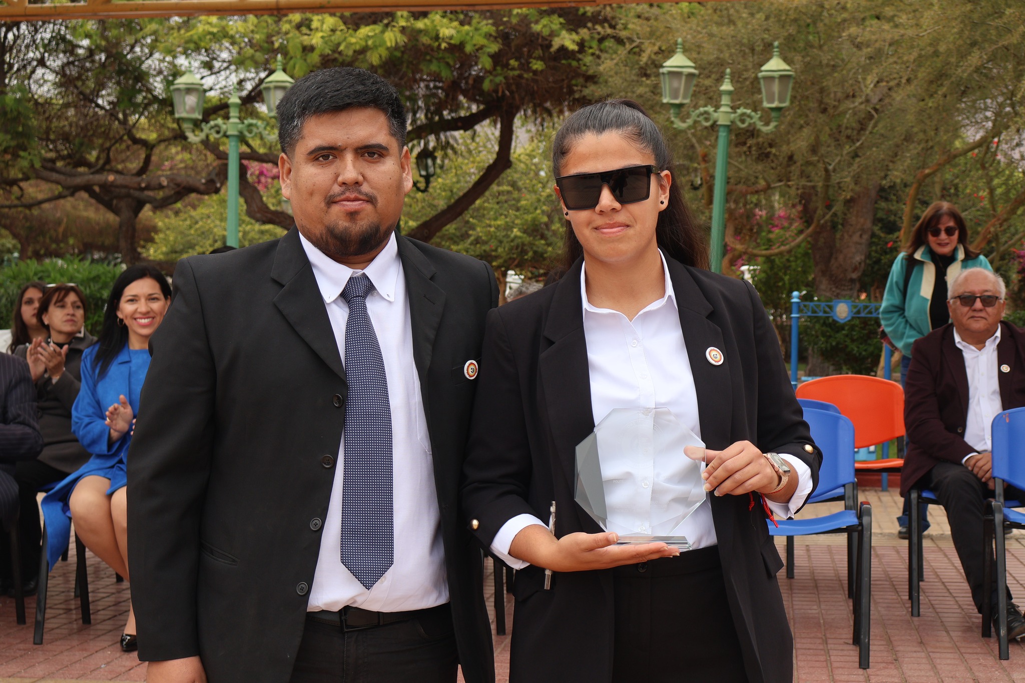 Integrante de la comunidad educativa recibe galvano en la ceremonia del Liceo Politécnico en Plaza Arturo Prat.