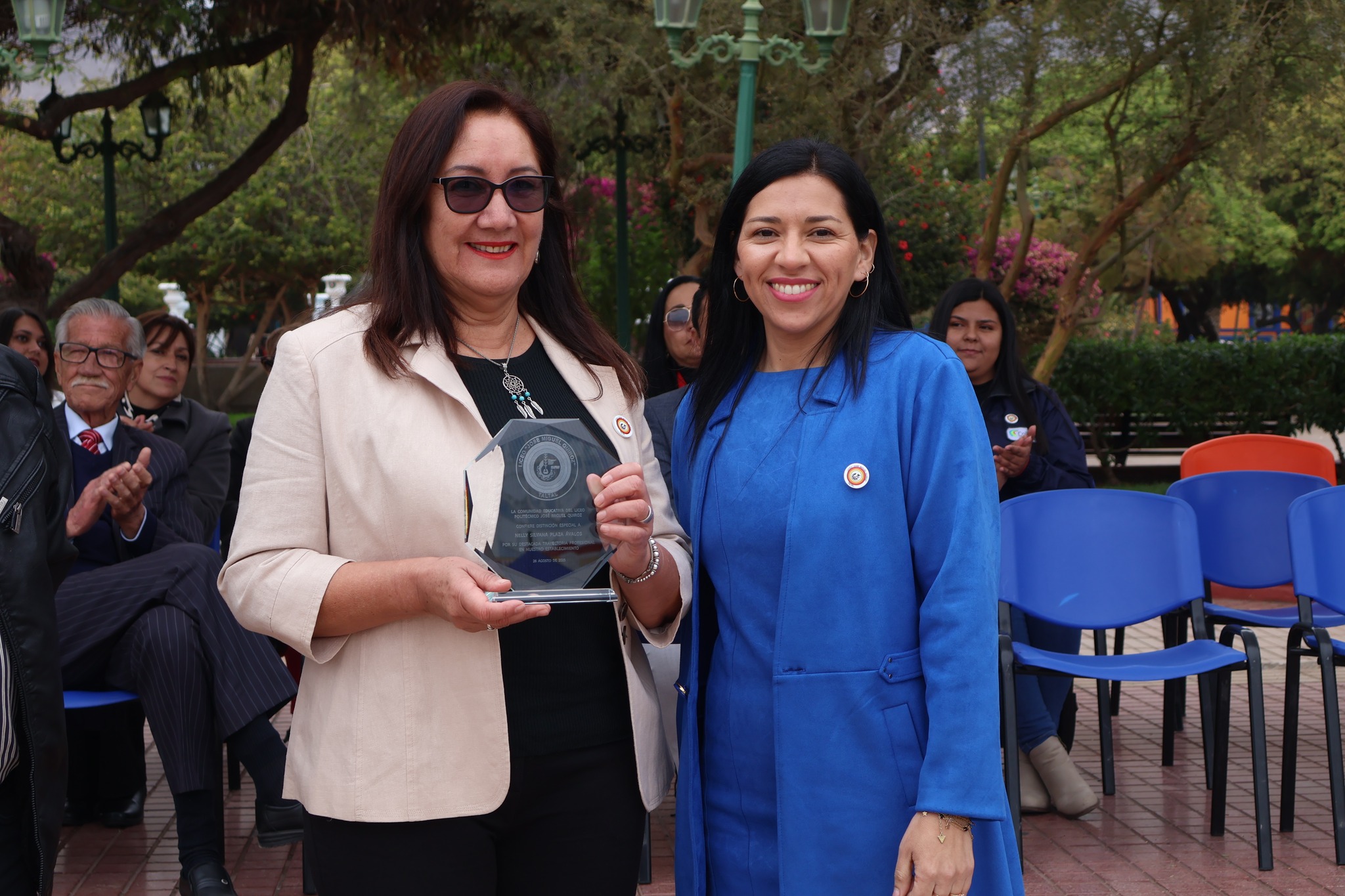 Autoridades del Liceo Politécnico entregan galvano de reconocimiento a funcionaria durante el acto aniversario en Plaza Arturo Prat.