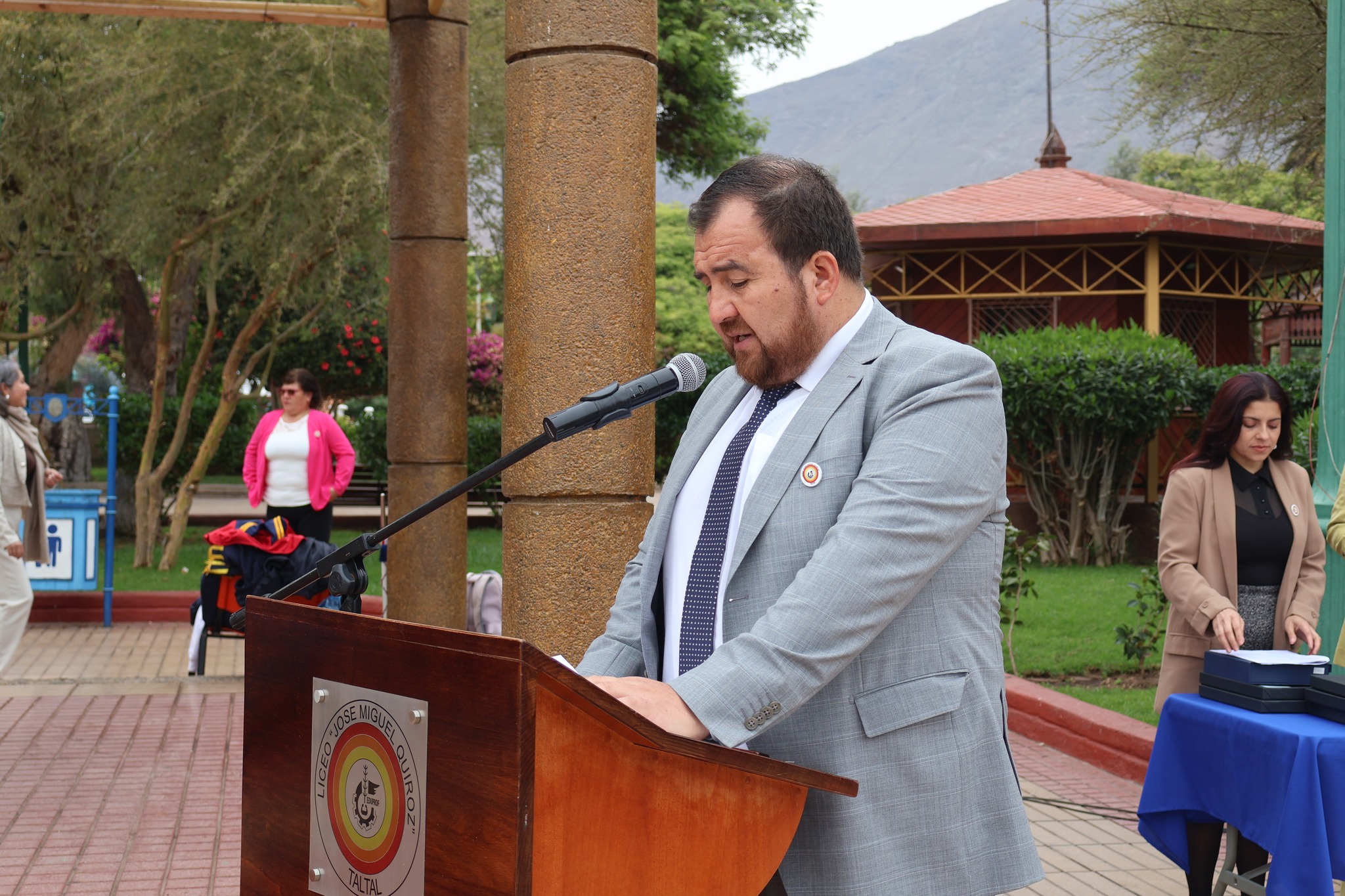 Representante del área docente se dirige al público desde el podio del Liceo José Miguel Quiroz en la ceremonia.