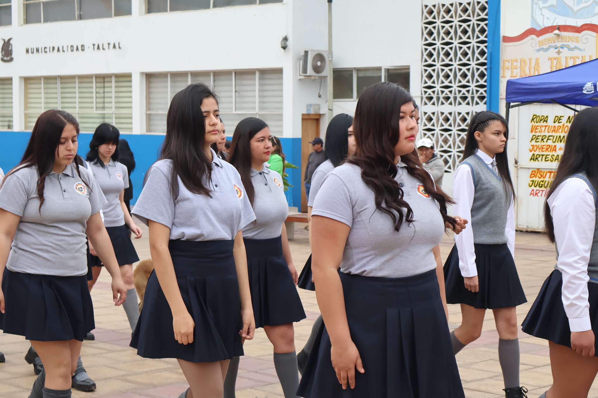 Grupo de alumnas con polera gris y falda azul participa del desfile del 86° aniversario.