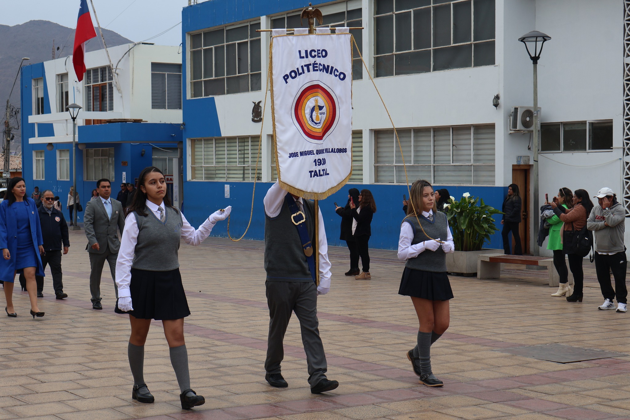 Portaestandarte y escoltas del Liceo Politecnico Jose Miguel Quiroz encabezan el desfile en la plaza.