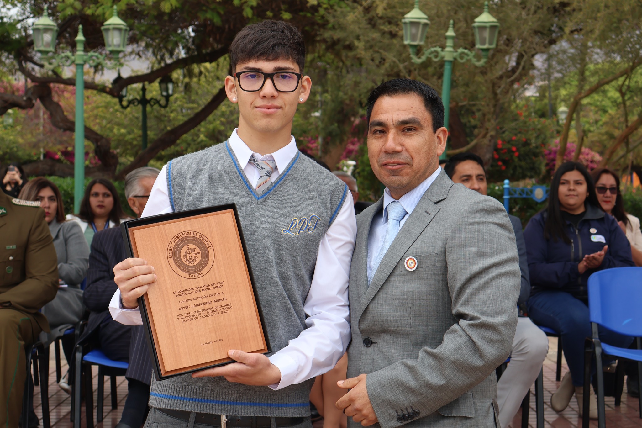 Estudiante de IV medio recibe placa de reconocimiento por desempeño académico en el aniversario del establecimiento.
