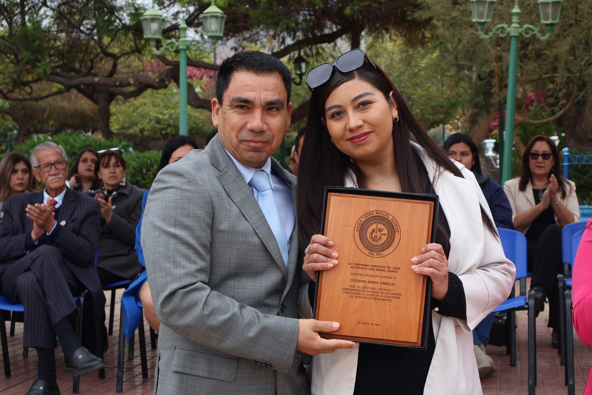Autoridad educacional entrega placa a apoderada destacada por desempeño y compromiso.