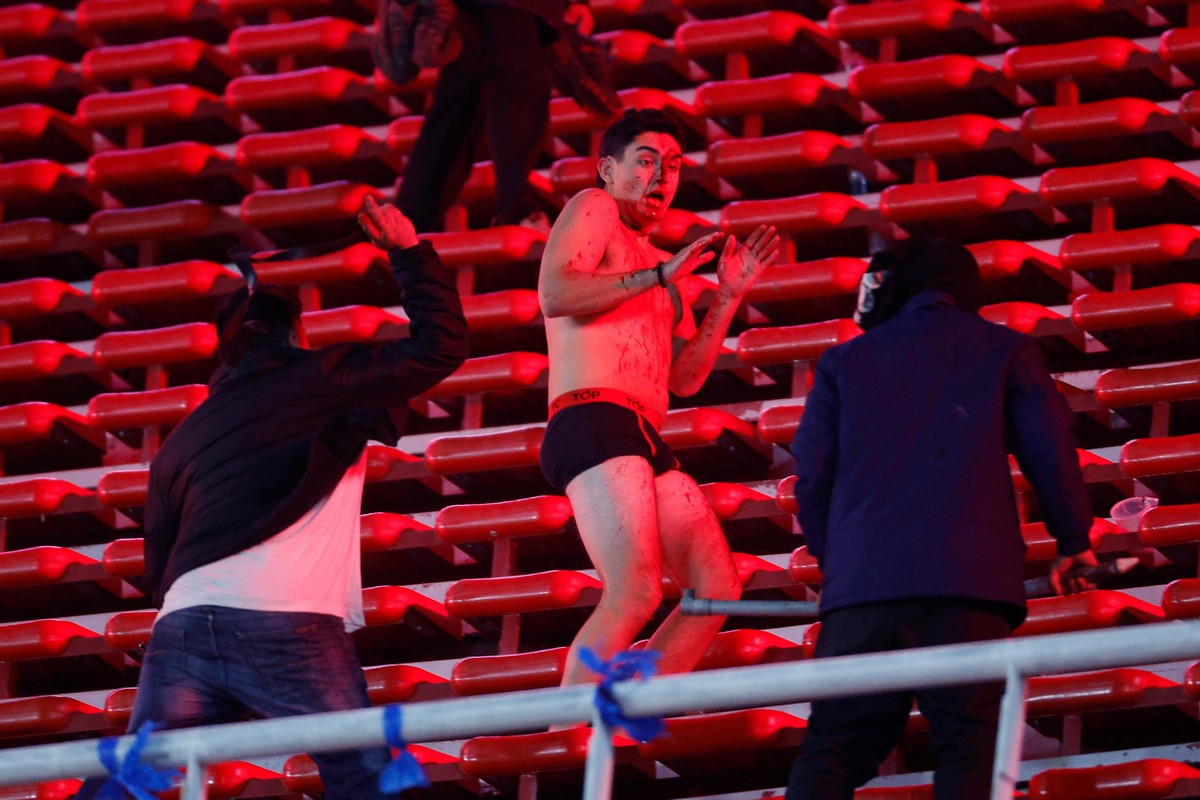 Un hincha de la Universidad de Chile, desnudo, en medio de la tribuna. Foto: EFE/ Juan Ignacio Roncoroni