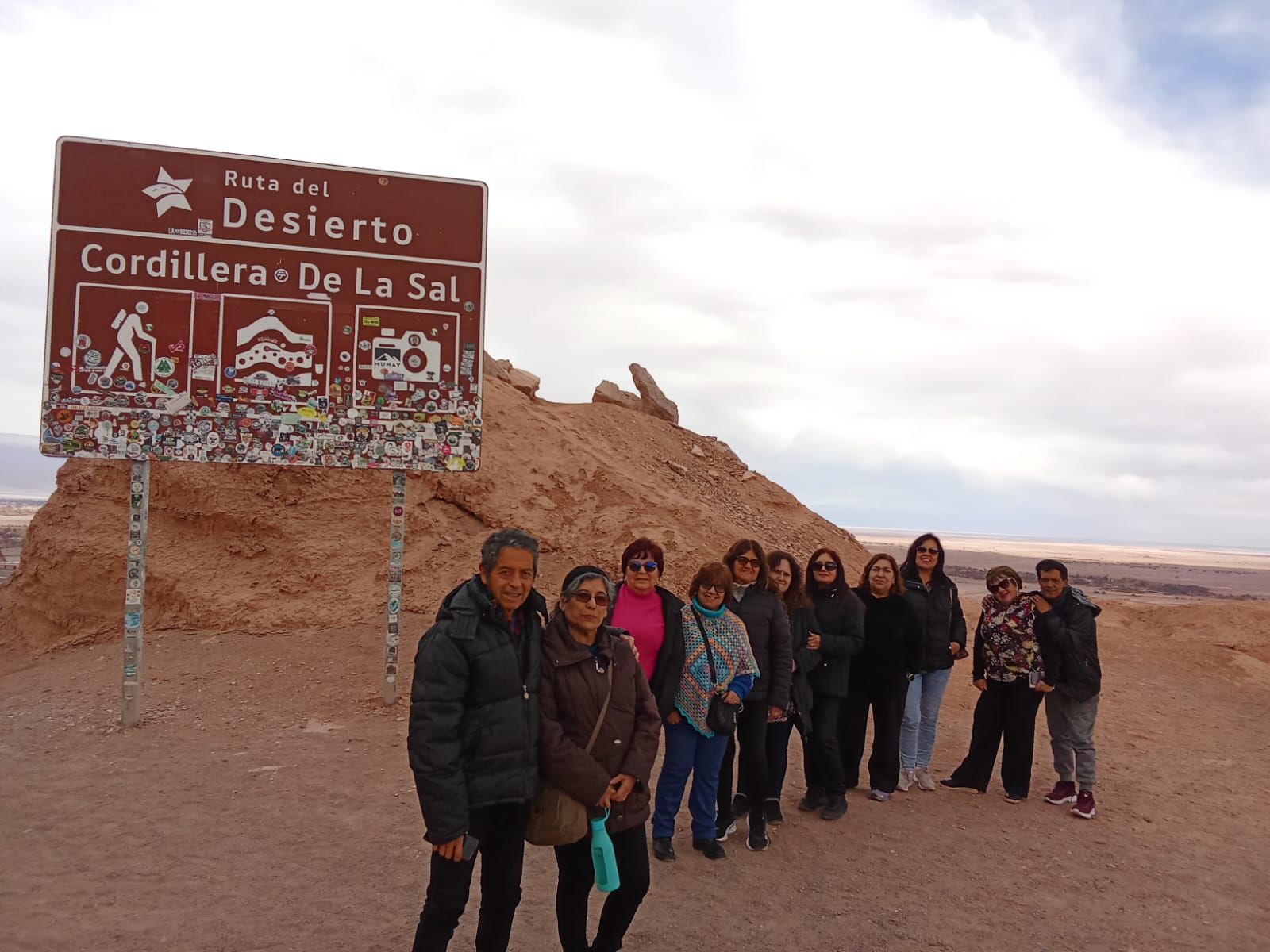 Delegación de personas mayores de Taltal junto al letrero Ruta del Desierto, Cordillera de la Sal.