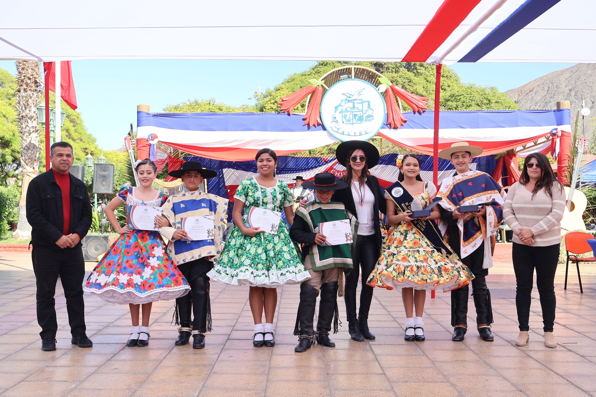 Ganadores de 5º a 8º básico reciben diplomas y trofeos en la Plaza Arturo Prat durante el Campeonato Comunal de Cueca de Taltal 2025.