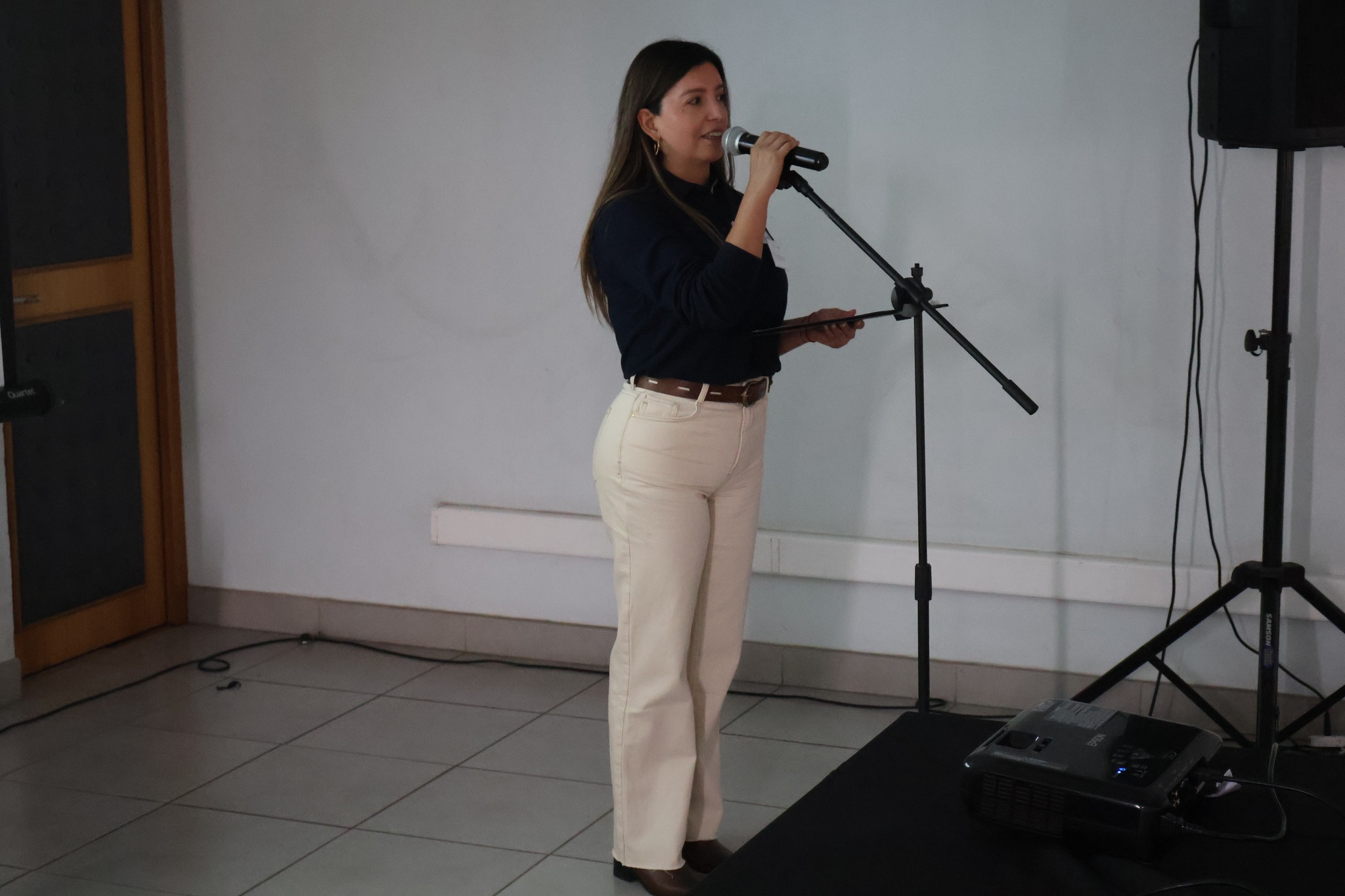 Expositora de Fundación Junto al Barrio explicando, con micrófono, las bases del Fondo Social