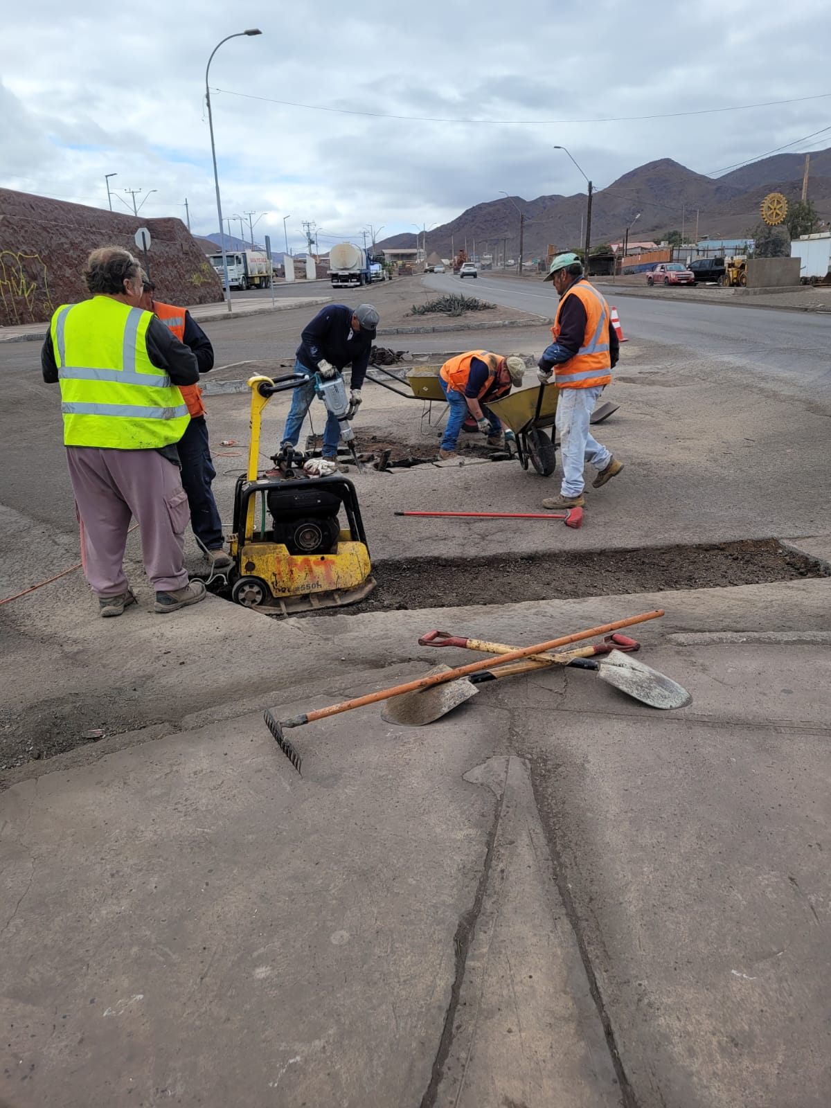 Equipo con chalecos reflectantes corta y prepara la caja para un parche asfáltico en la Av.Bilbao, sector sur de Taltal.