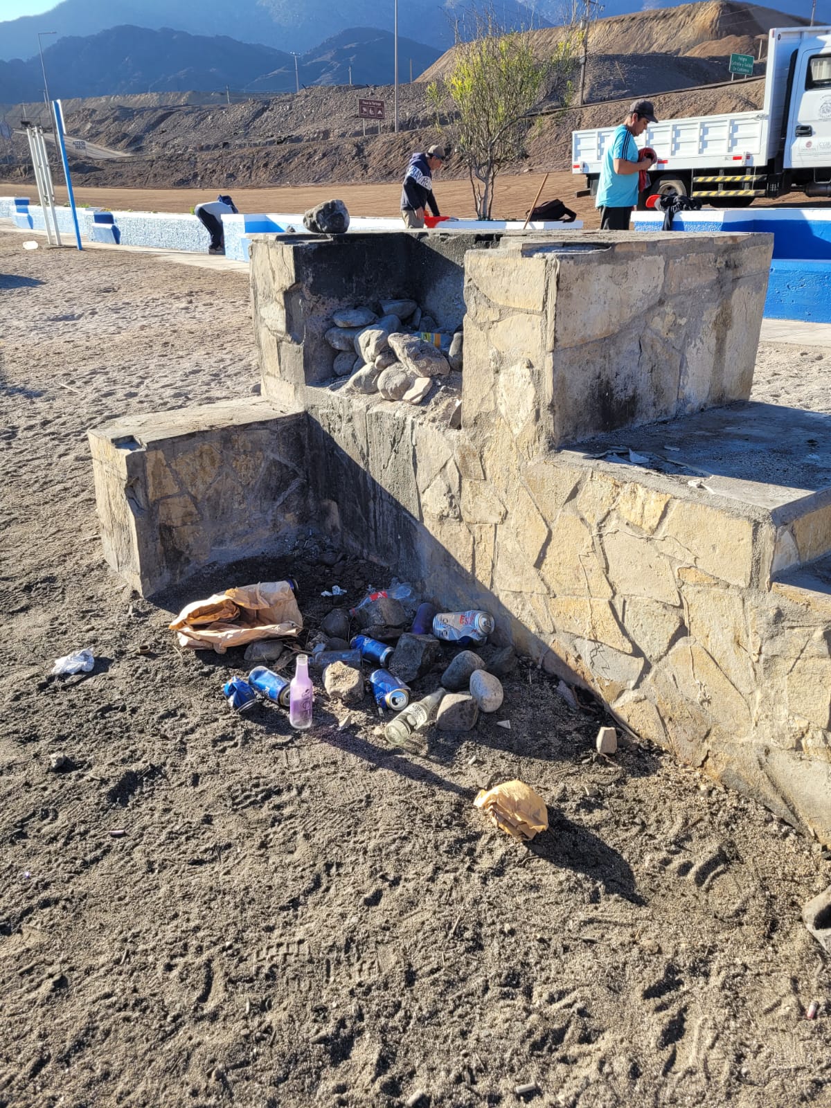 Antes del operativo: parrilla del quincho con botellas y residuos acumulados en el sector Muelle de Piedra