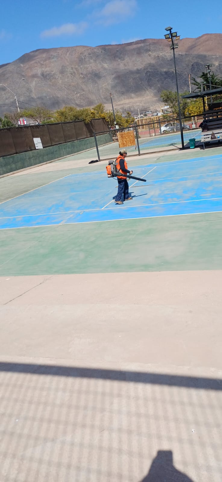 Operario usando soplador para retirar polvo de la superficie.