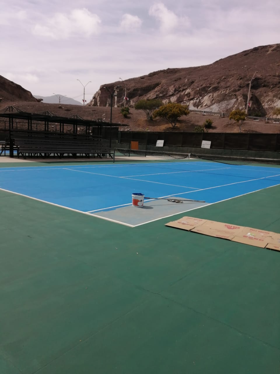 Cancha terminada con pintura azul y líneas demarcadas.