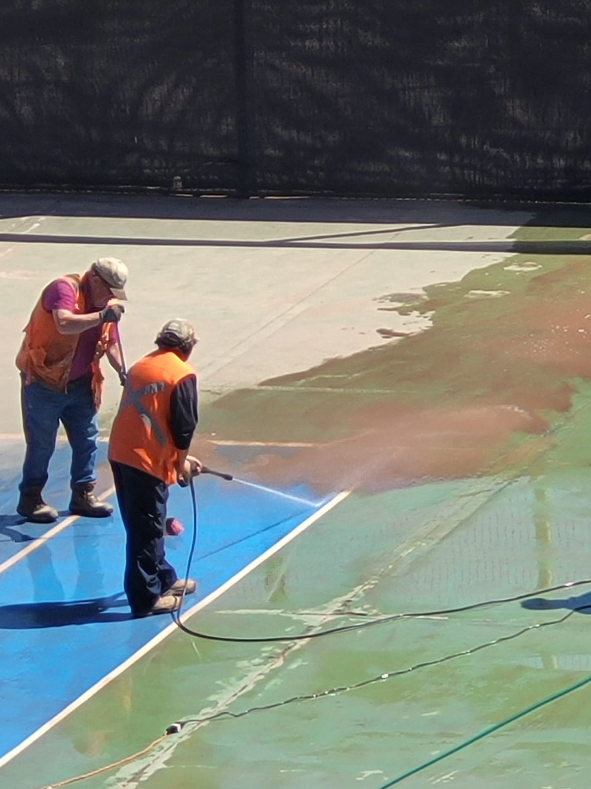 Cuadrilla realizando hidrolavado del borde de la cancha