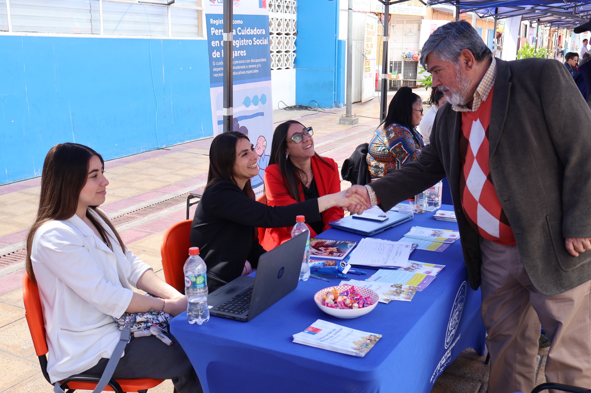Autoridades saludan a funcionarias en mesa de programas sociales durante Gobierno en Terreno en Plaza Prat.