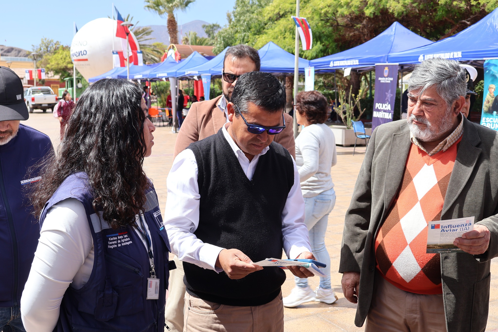 Autoridades revisan folletería informativa de servicios de fiscalización y salud durante la actividad.