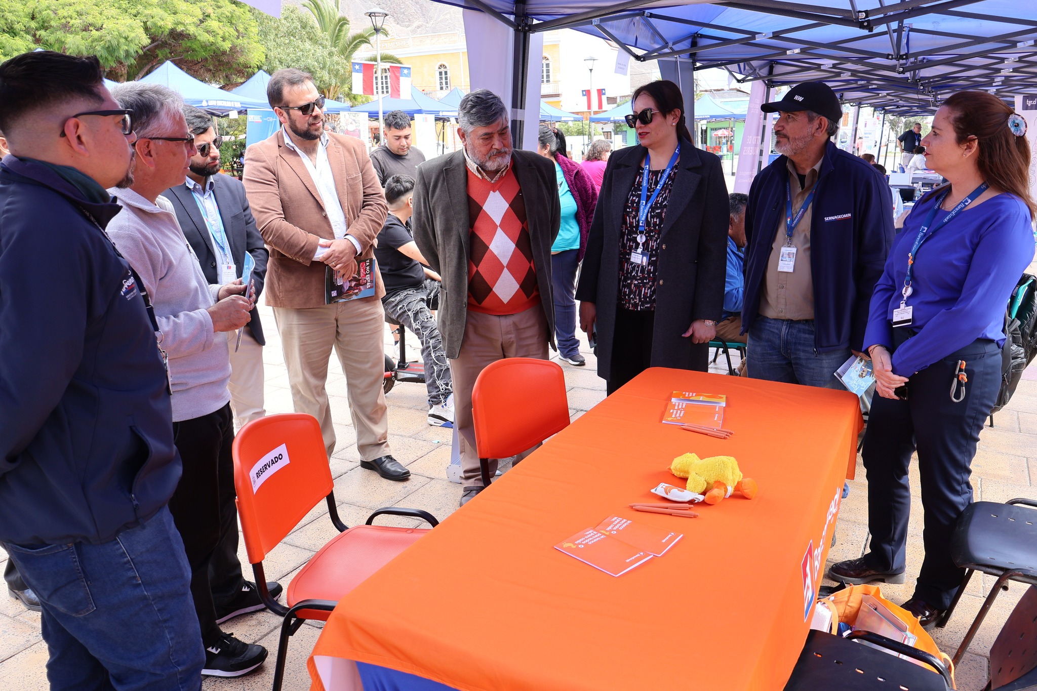 Comitiva de autoridades recorre la feria y conversa en el stand de BancoEstado en Plaza Prat de Taltal.