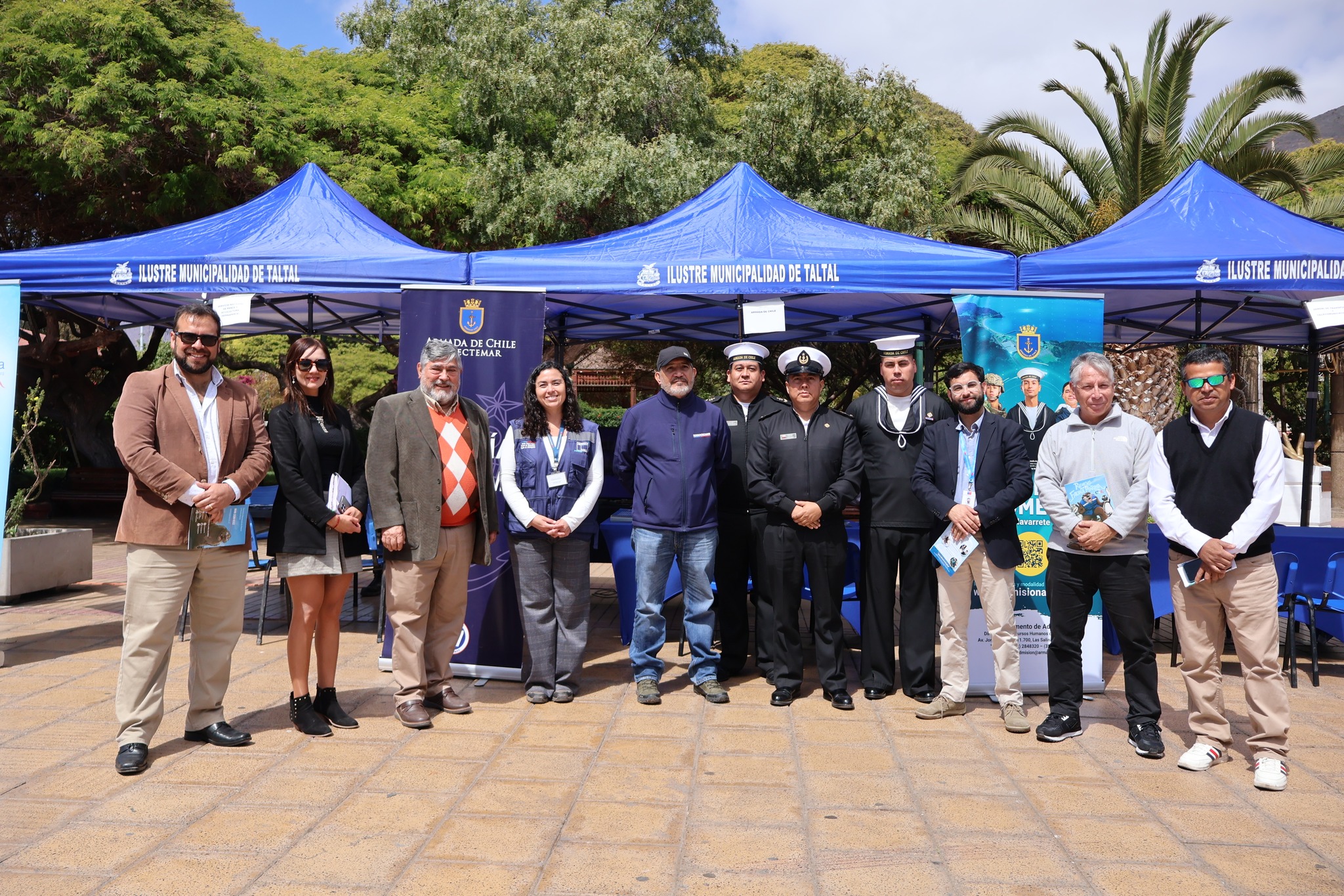 Foto oficial de autoridades, Armada y equipos de servicios públicos frente a carpas del municipio de Taltal.