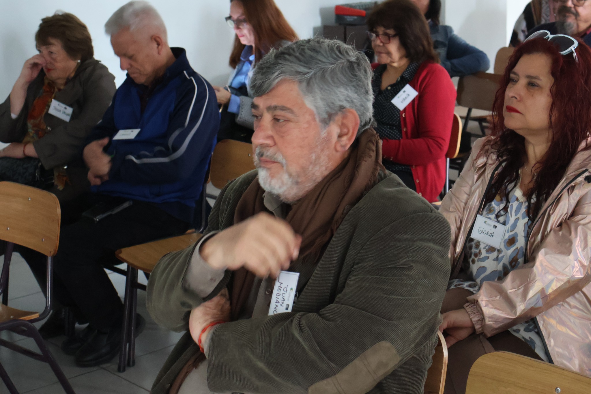 Primer plano de asistentes escuchando atentamente los requisitos del fondo.