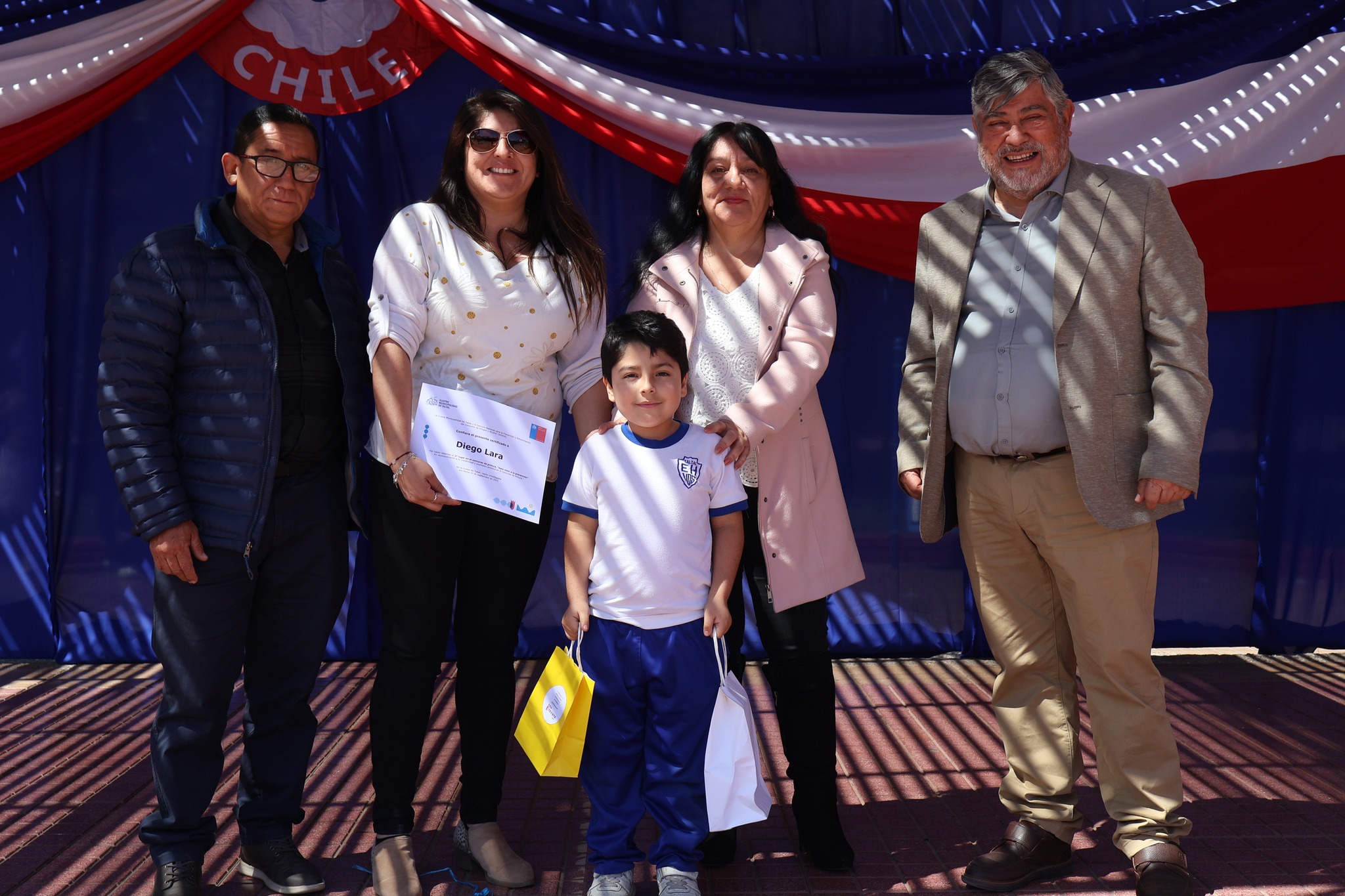 Alumno Diego Lara junto a autoridades en premiación de concurso Dale Color a la Prevención