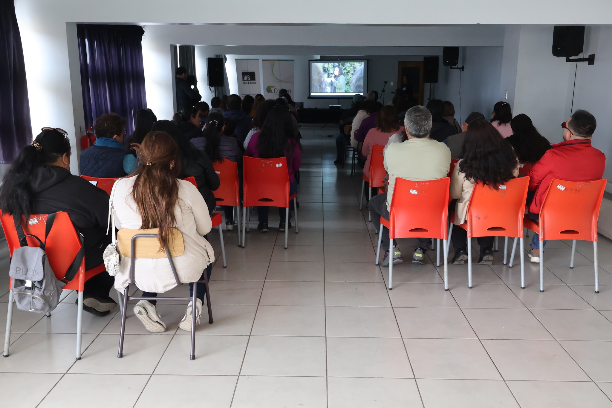 Presentación con pantalla y banners de Colbún y Fundación JAB al fondo de la sala.