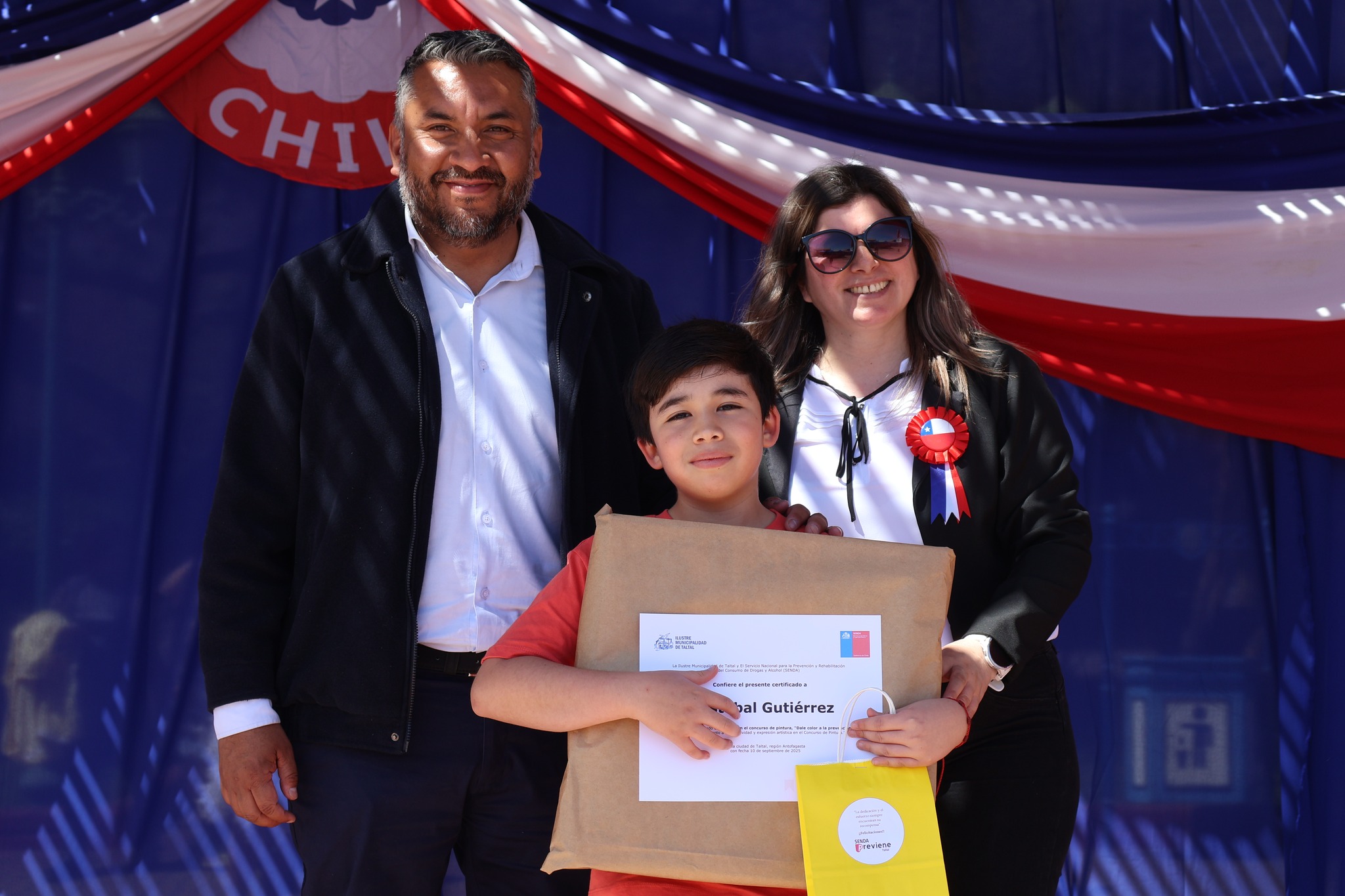Estudiante premiado junto a autoridades en la Fonda Preventiva de Taltal