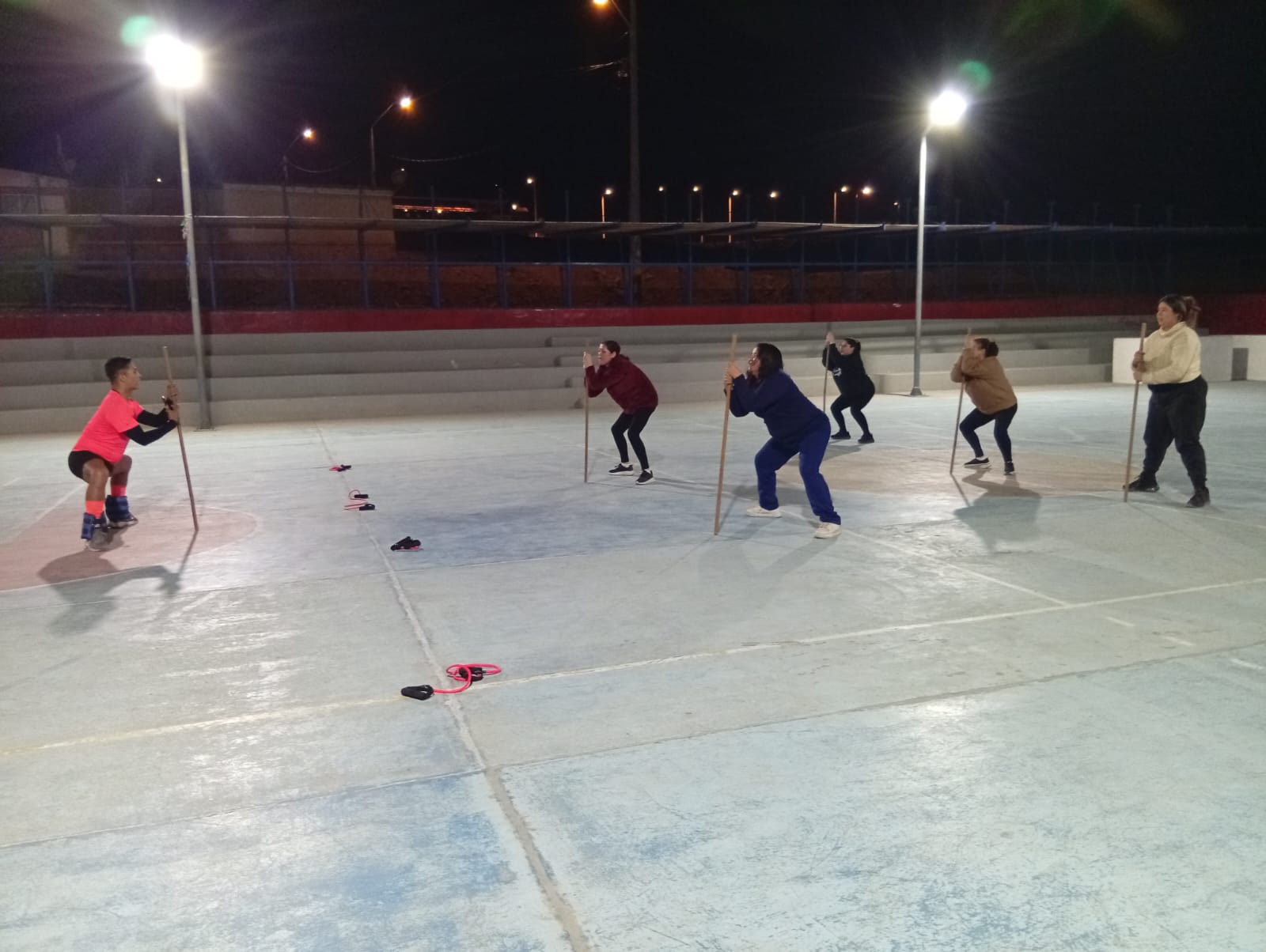 Profesor guía a participantes en sesión de entrenamiento con bandas elásticas en Paposo.