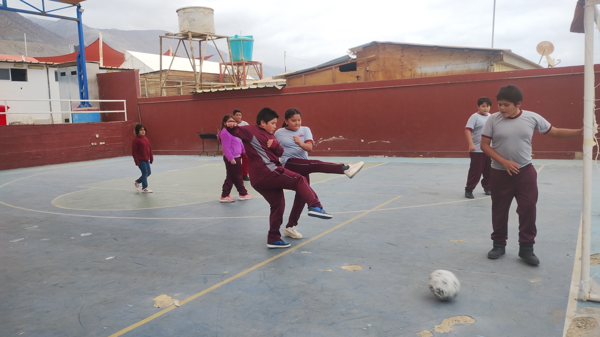Estudiantes de Paposo disputan partido de babyfútbol en la multicancha del colegio.