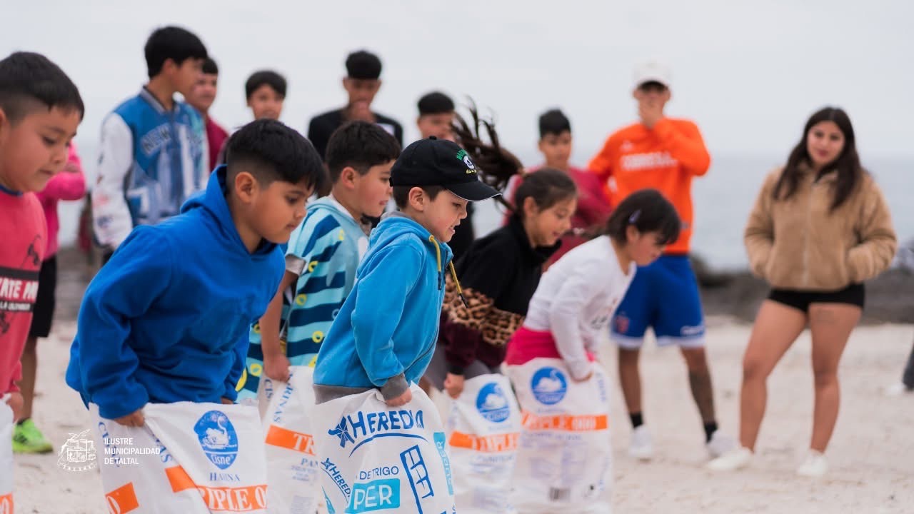 Niños compitiendo en carrera de sacos durante los Juegos Criollos en Poza Las Peñas, Taltal.