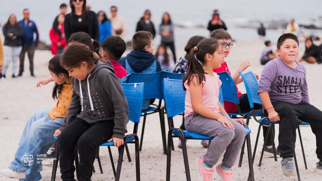 Niños participando en la silla musical infantil frente al mar en Taltal.