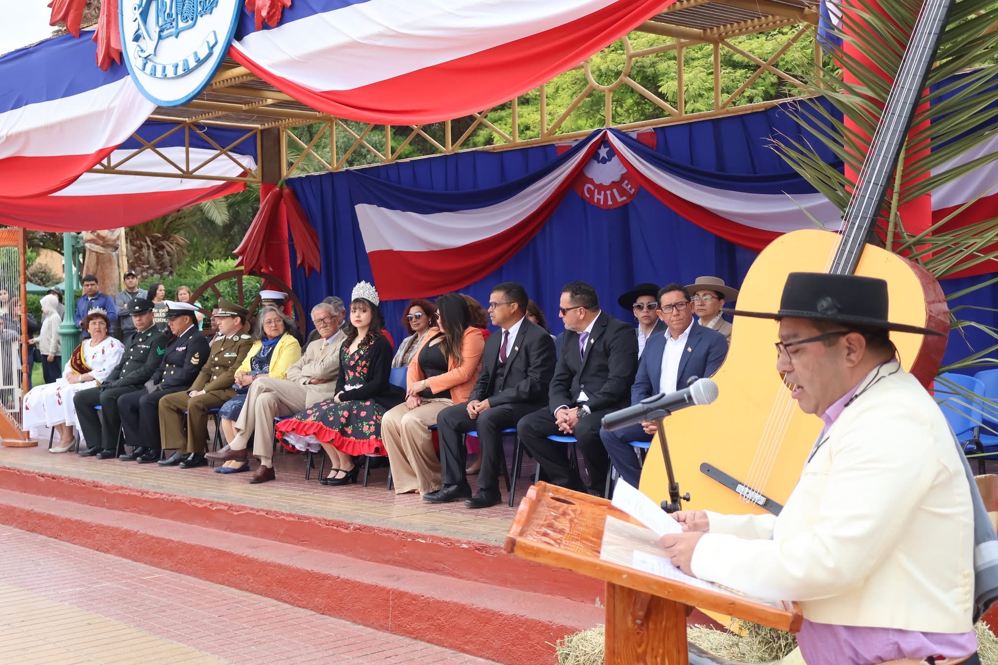 Alocución patriótica n el acto oficial de Taltal, con autoridades y reinas comunales en el palco.