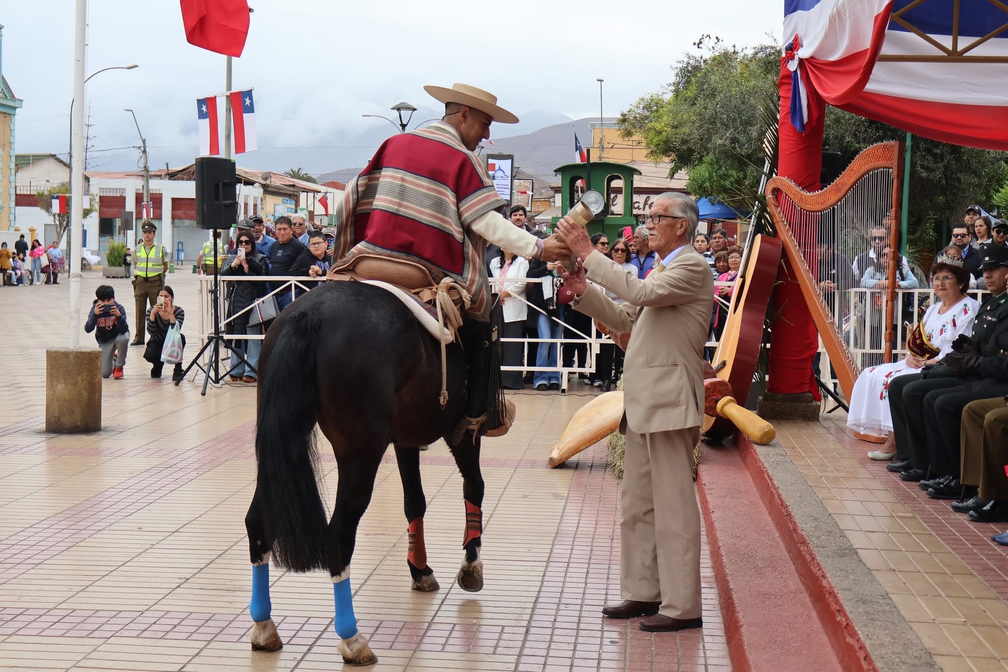 Brindis de chicha en cacho frente al palco durante las Fiestas Patrias en Taltal.