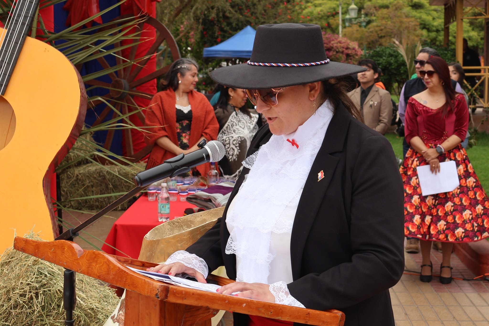 Oradora con traje tradicional da el mensaje central del acto de Fiestas Patrias en Taltal.