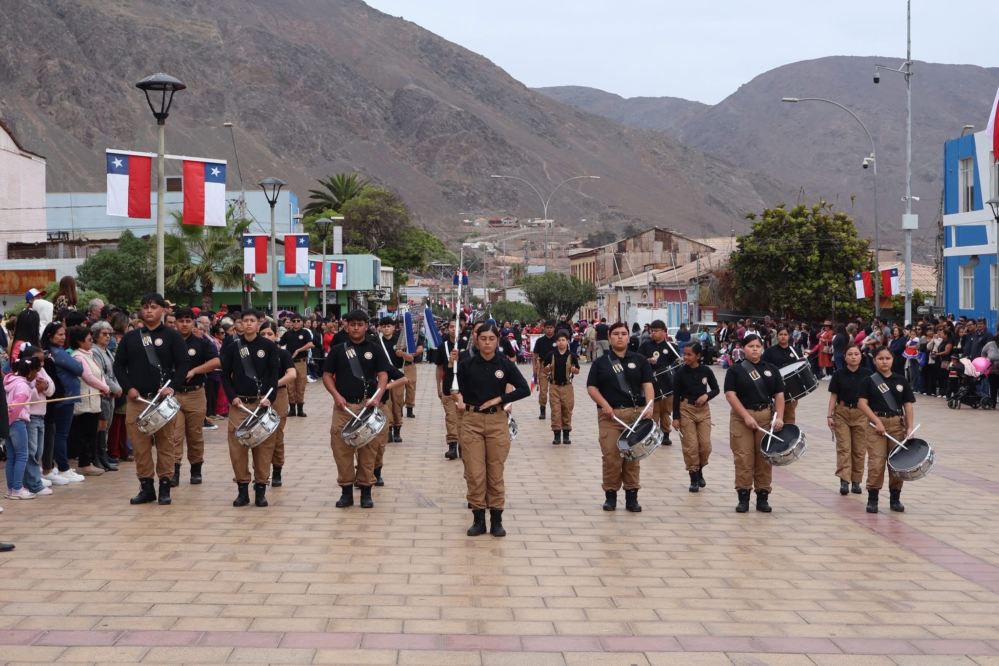 Banda escolar avanza por la avenida principal en el desfile cívico de Taltal.