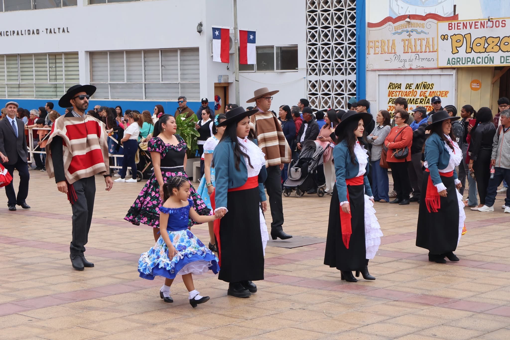 Docentes y estudiantes con vestimenta huasa avanzan en formación por la Plaza de Armas de Taltal durante el desfile.