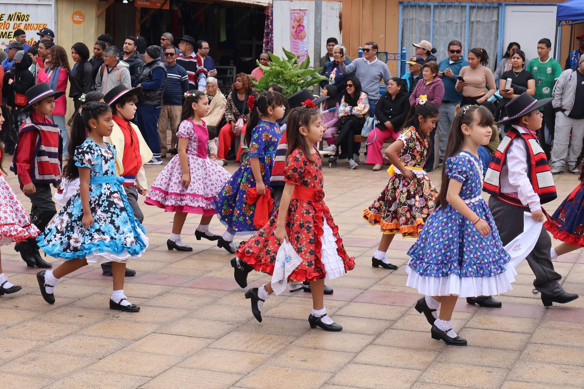 Niñas con coloridos vestidos de cueca marchan con pañuelos en mano en el desfile de Fiestas Patrias de Taltal.