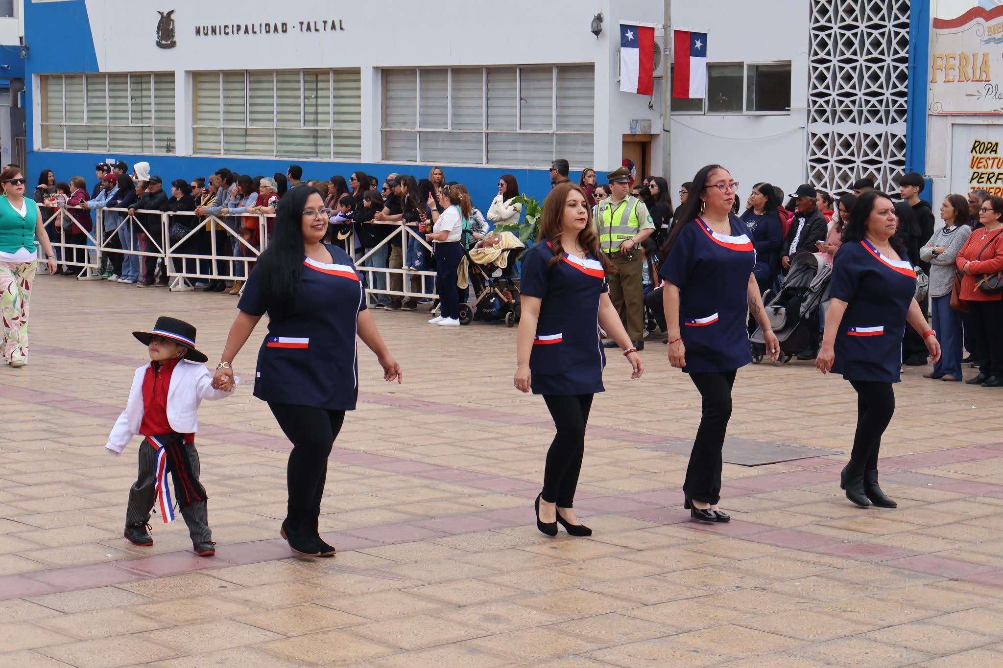 Educadoras marchan con un niño vestido de huaso frente a la Municipalidad de Taltal durante el desfile de Fiestas Patrias.