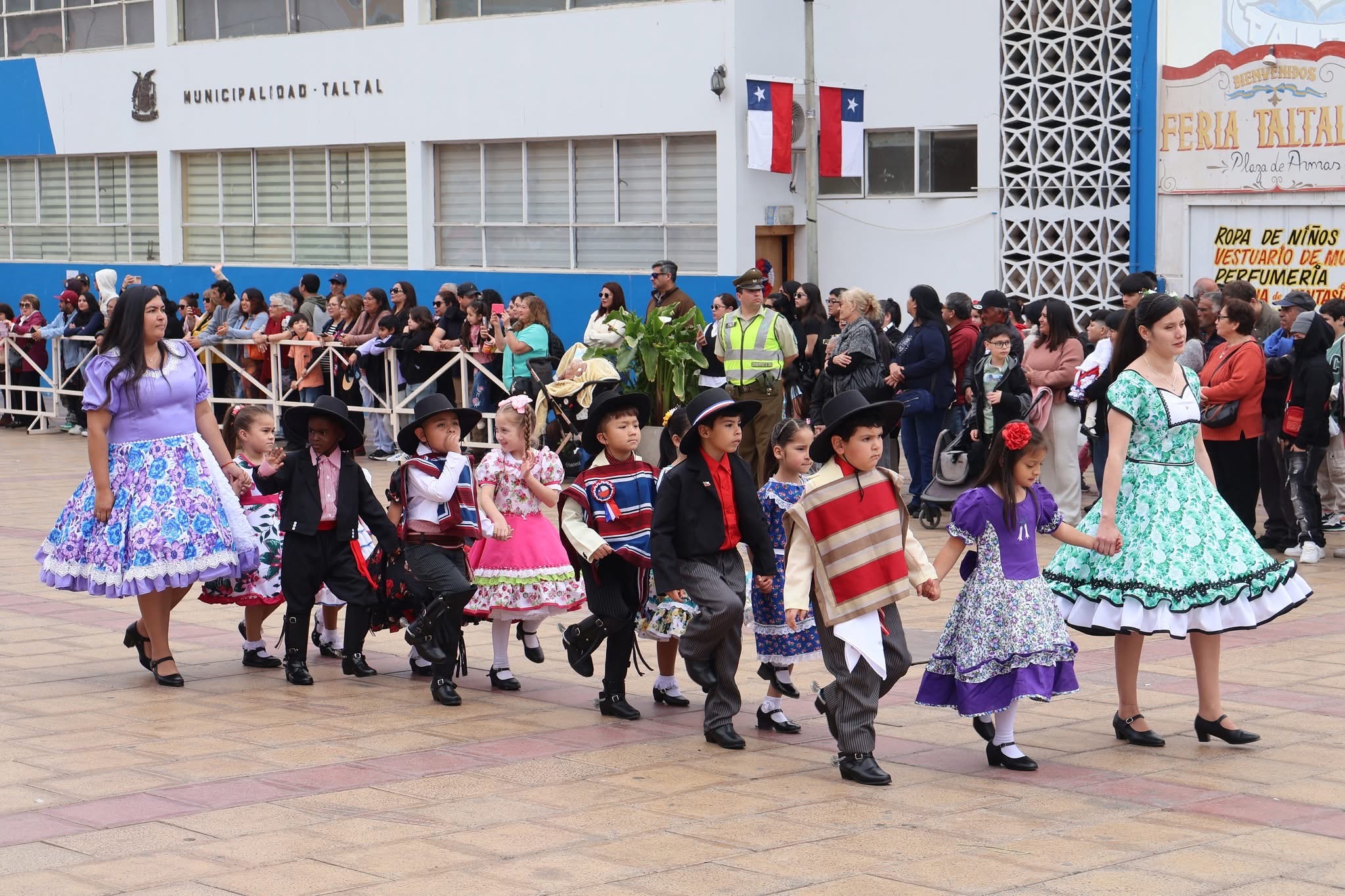 Niñas y niños desfilan con trajes típicos chileno acompañados por sus educadoras en la Plaza de Armas de Taltal