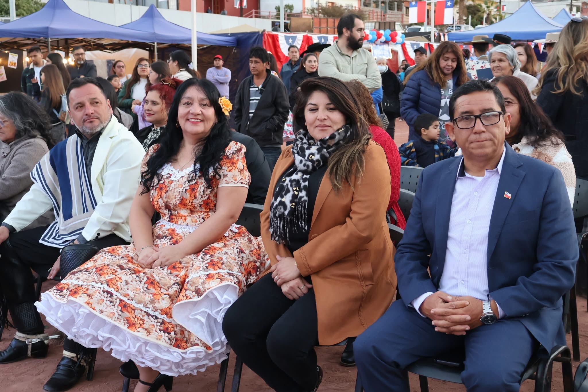 Equipo municipal e invitados especiales en primera fila durante la ceremonia, con vestimenta tradicional y ambiente festivo en el sector de ramadas.
