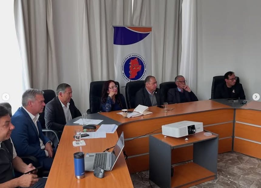 Reunión de AMRA con equipos municipales; cuaderno de notas y proyector sobre la mesa.