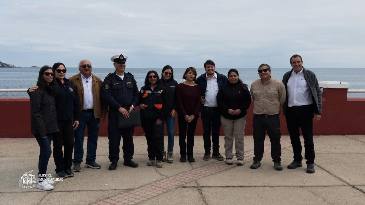 Autoridades locales y representantes de instituciones públicas y privadas posan en el borde costero tras la limpieza de playas en Taltal.