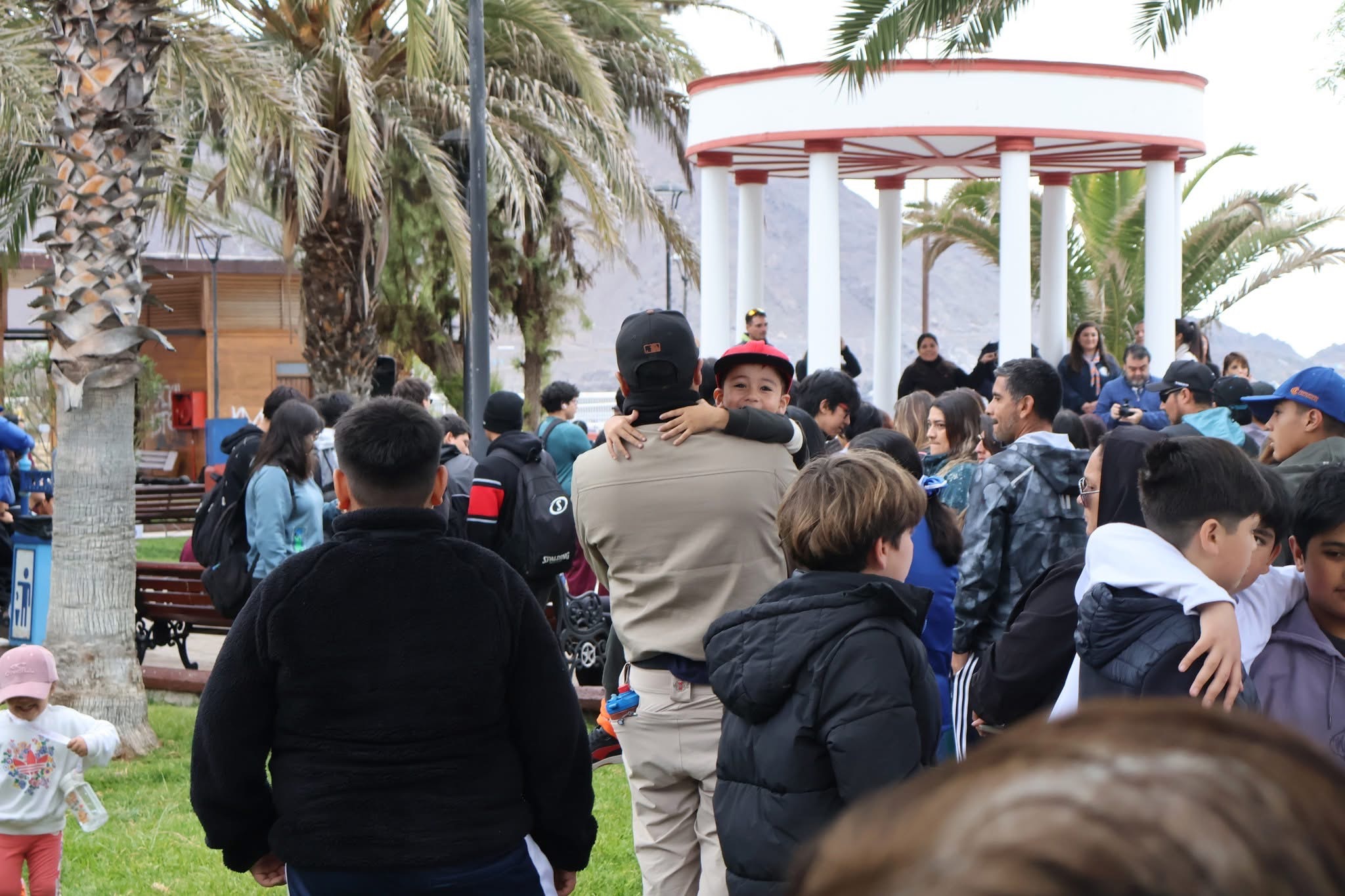 Ambiente familiar en la jornada de limpieza de playas en Taltal, con niños y jóvenes compartiendo en la plaza.