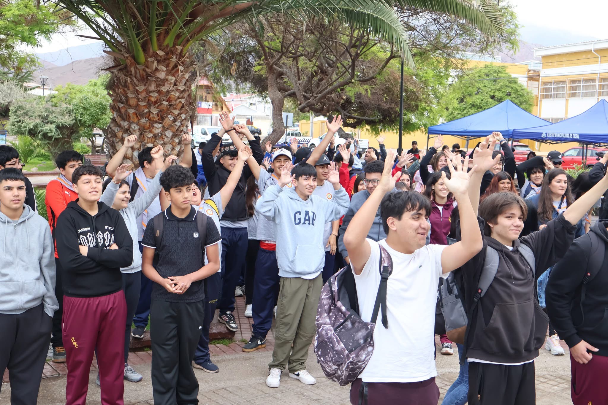 Jóvenes de Taltal levantan las manos en señal de entusiasmo durante la jornada de limpieza de playas 2025.