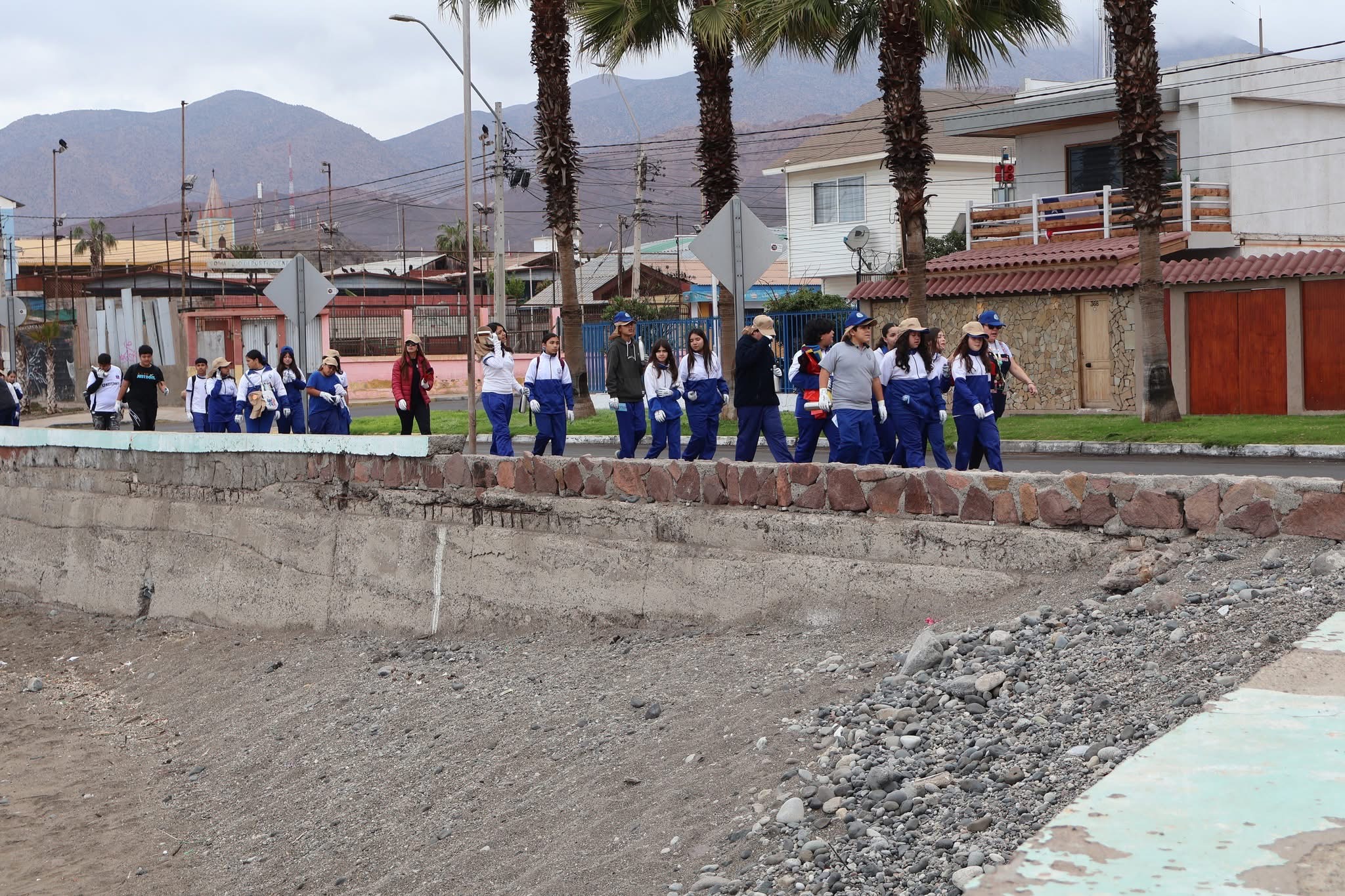 Delegación de estudiantes de la Escuela Hogar Victoriano Quinteros Soto de Taltal caminando hacia la playa para unirse a la jornada de limpieza.