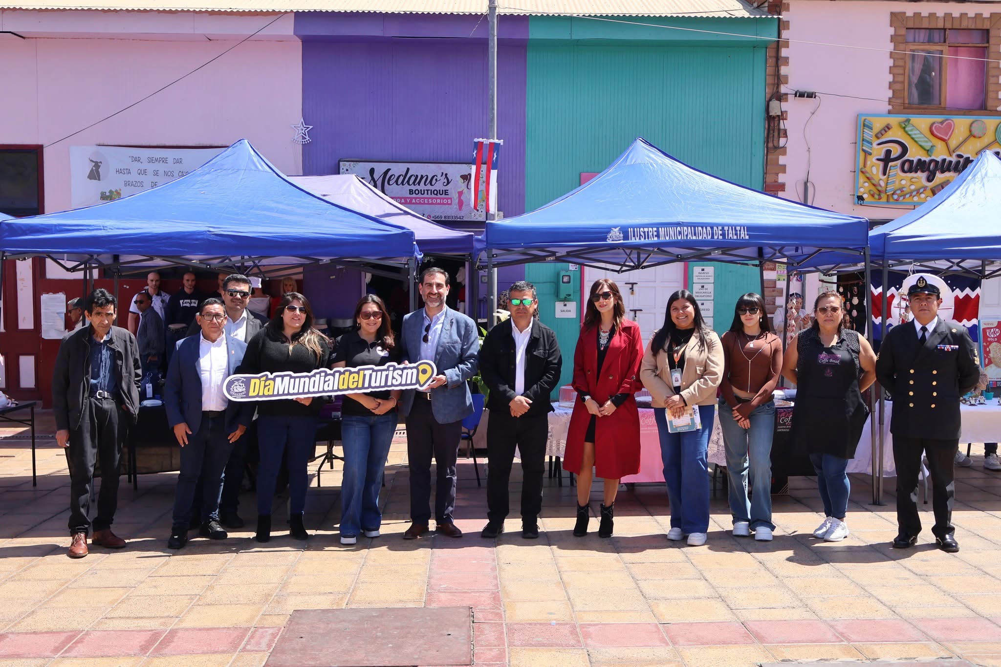 Emprendedores y autoridades sostienen cartel del Día Mundial del Turismo en Taltal.