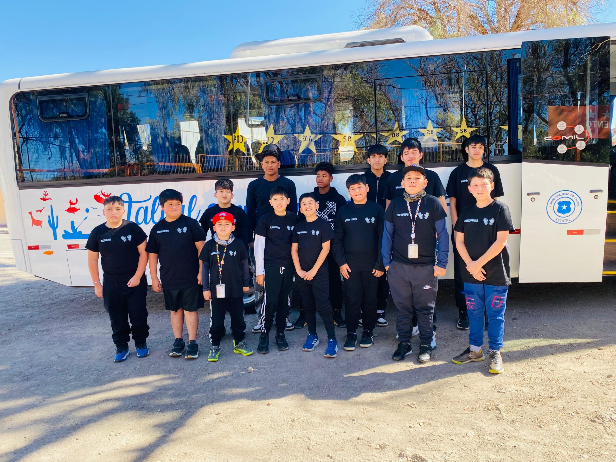 Delegación de jóvenes porteros de la Academia de Arqueros de Taltal posa frente al bus institucional antes de la jornada formativa en Calama.