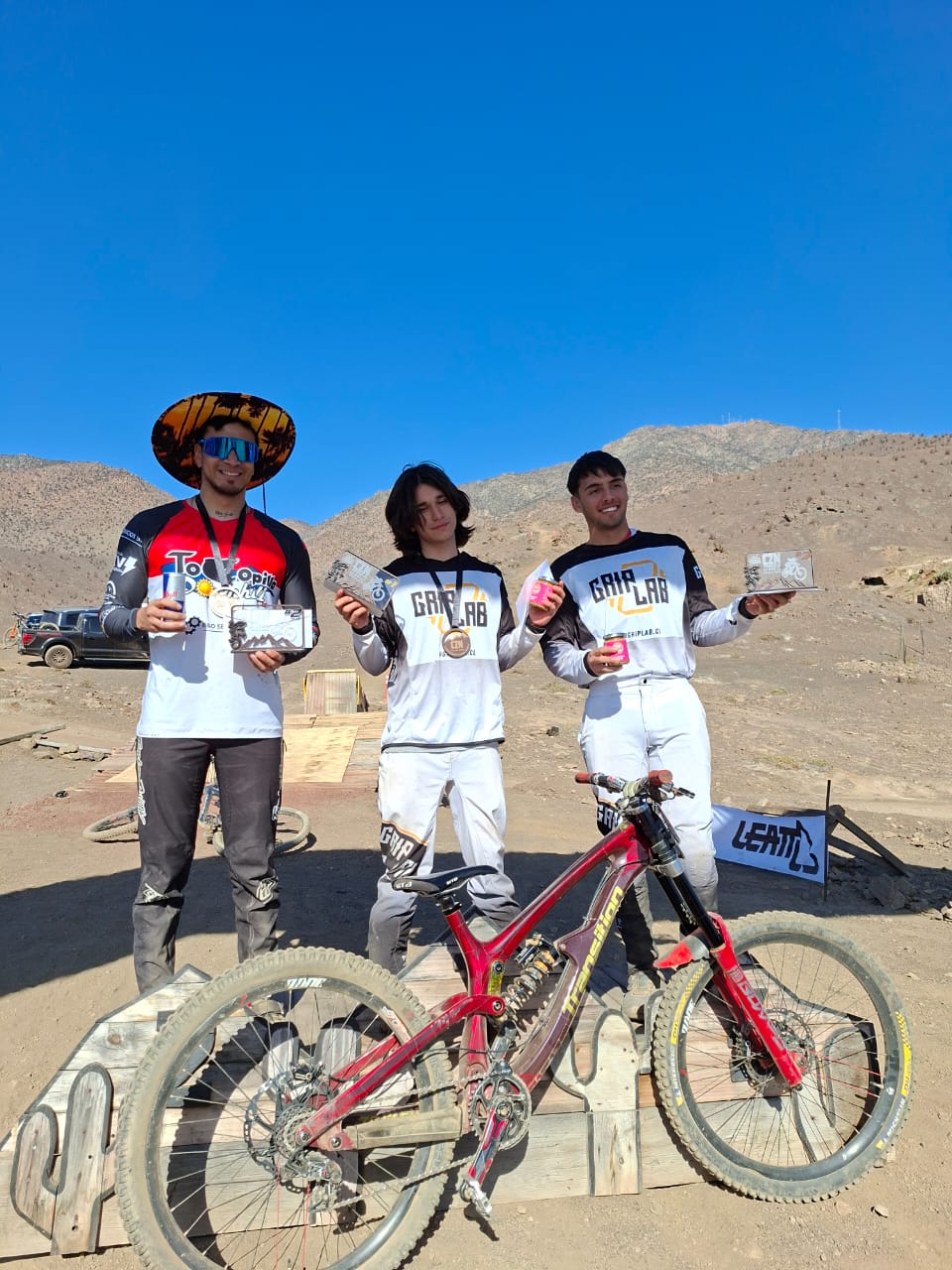 Riders taltalinos posan junto a su bicicleta tras obtener los primeros lugares del Campeonato Zonal Norte de Downhill en Taltal 2025.
