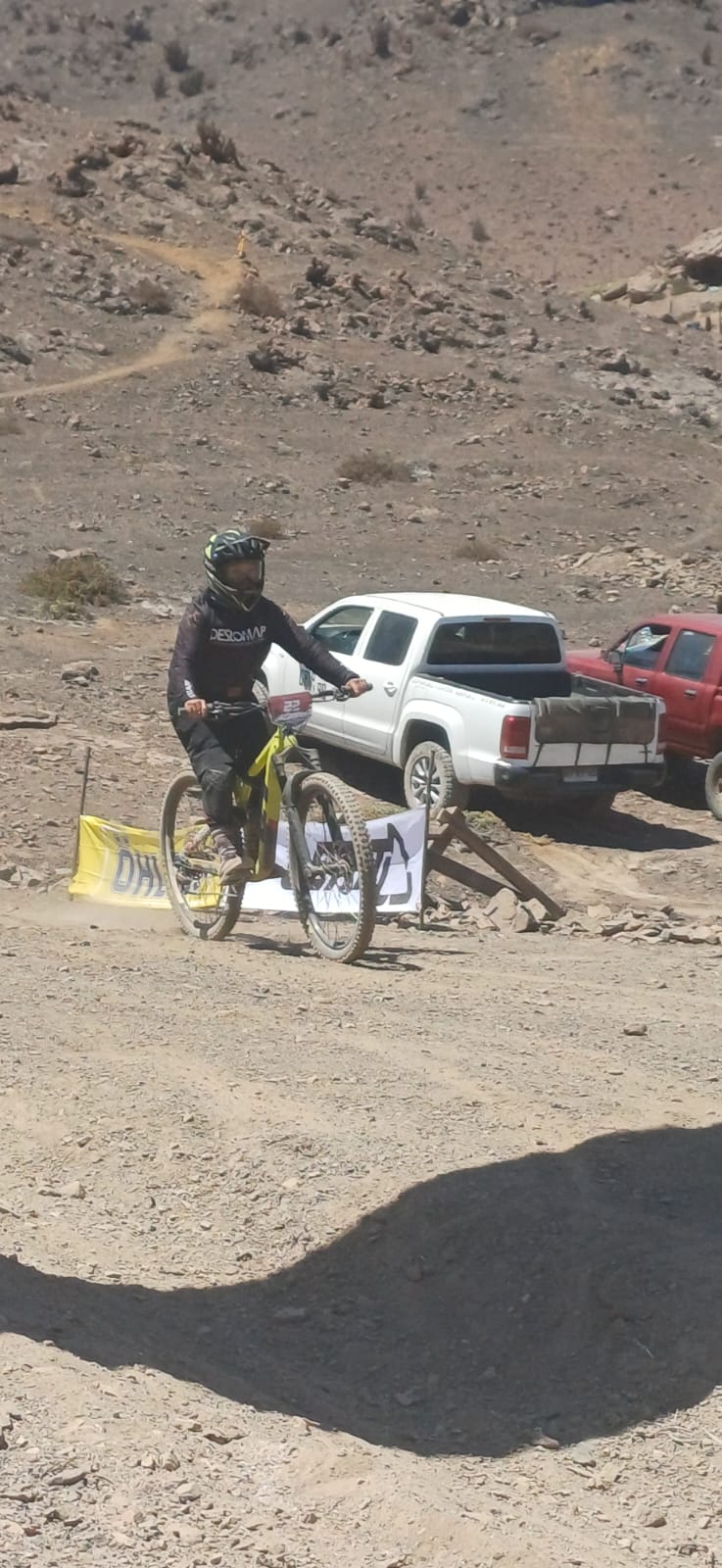 Ciclista taltalino cruza la meta con su bicicleta amarilla tras completar el recorrido del Downhill Zonal Norte.