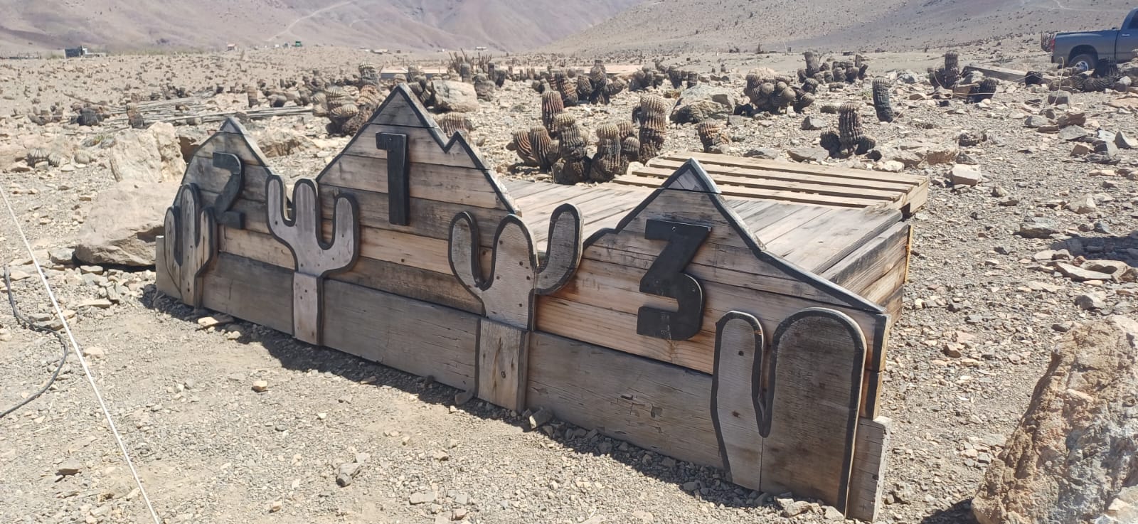 Podio de madera con forma de montañas y cactus preparado para la premiación del Downhill Zonal Norte en Taltal.