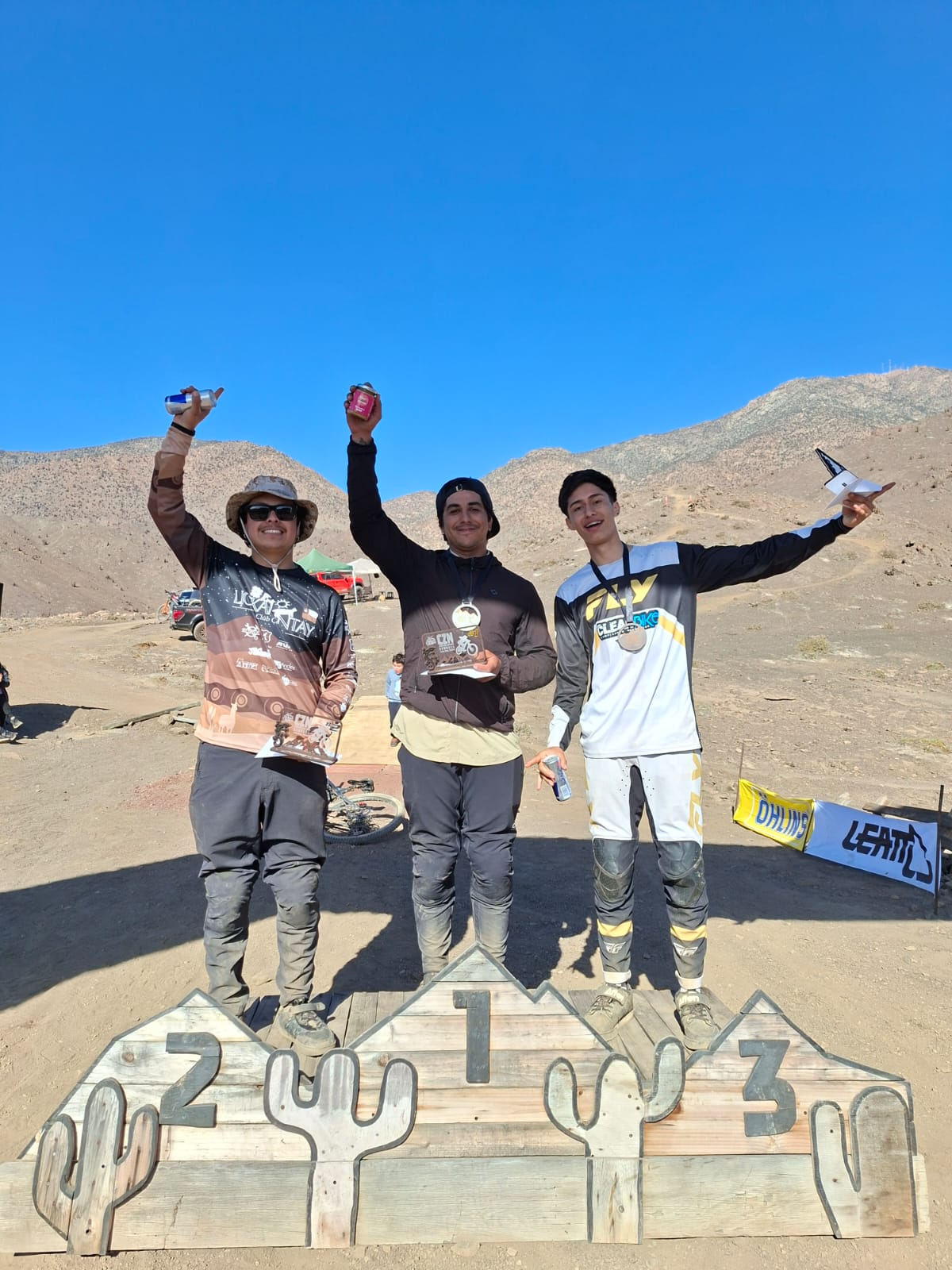 Corredor con casco negro y uniforme azul en pleno salto en la pista del campeonato de Downhill en Taltal.