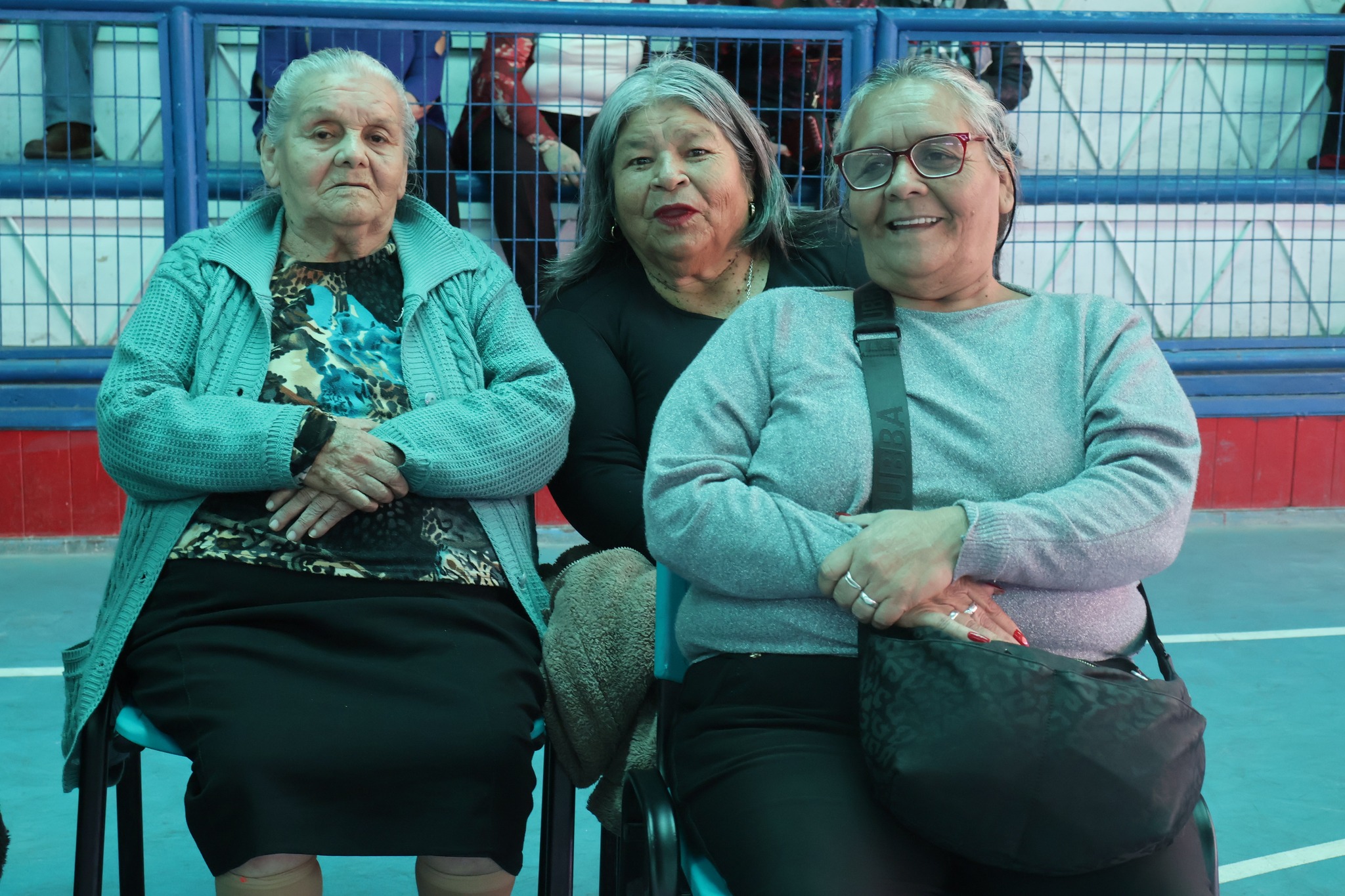 Grupo de mujeres mayores sentadas y disfrutando de las actividades recreativas de la jornada.